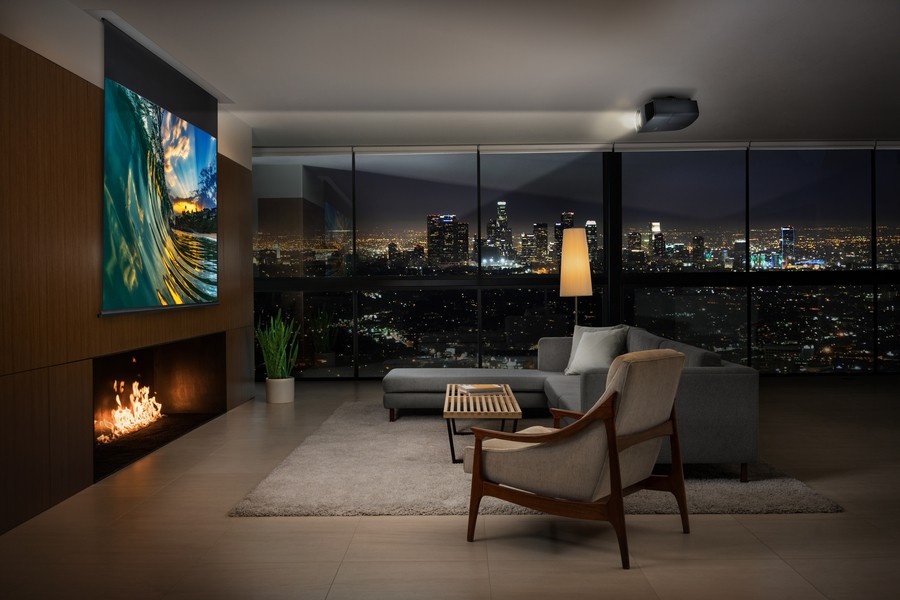 A living area with a Sony projector and a movie screen lowered from the ceiling.