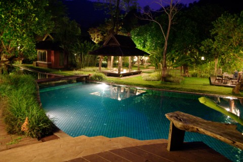 A pool surrounded by outdoor lighting.